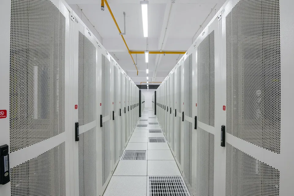 Rows of server racks in a data centre: Qwen's largest models are served from Alibaba Cloud halls of this kind