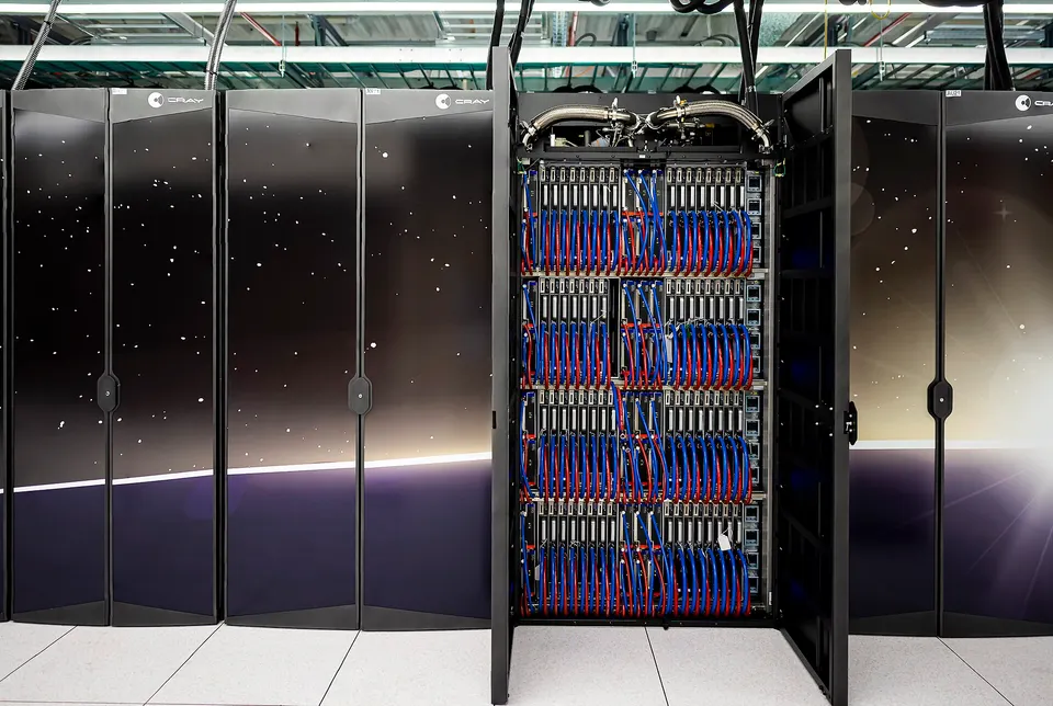 An open cabinet of Frontier, an AMD-GPU supercomputer at Oak Ridge, not Helios: liquid-cooled GPU blades packed into one rack, the idea Helios scales up