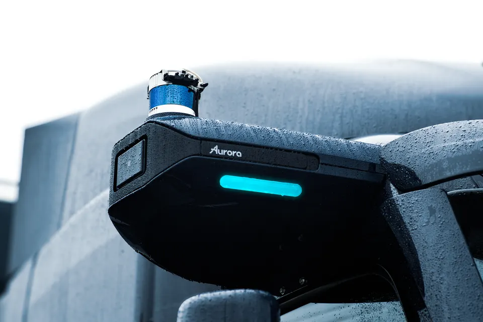 Aurora's sensor pod on a Peterbilt truck in the rain: cameras and radar in the housing, a spinning lidar on top