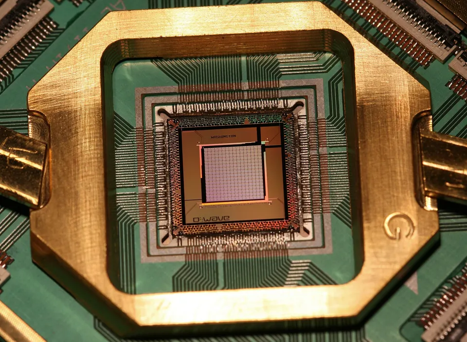 A D-Wave 2X annealing chip (2015) wire-bonded in its holder, not Advantage2: the qubits are superconducting loops etched on the central chip