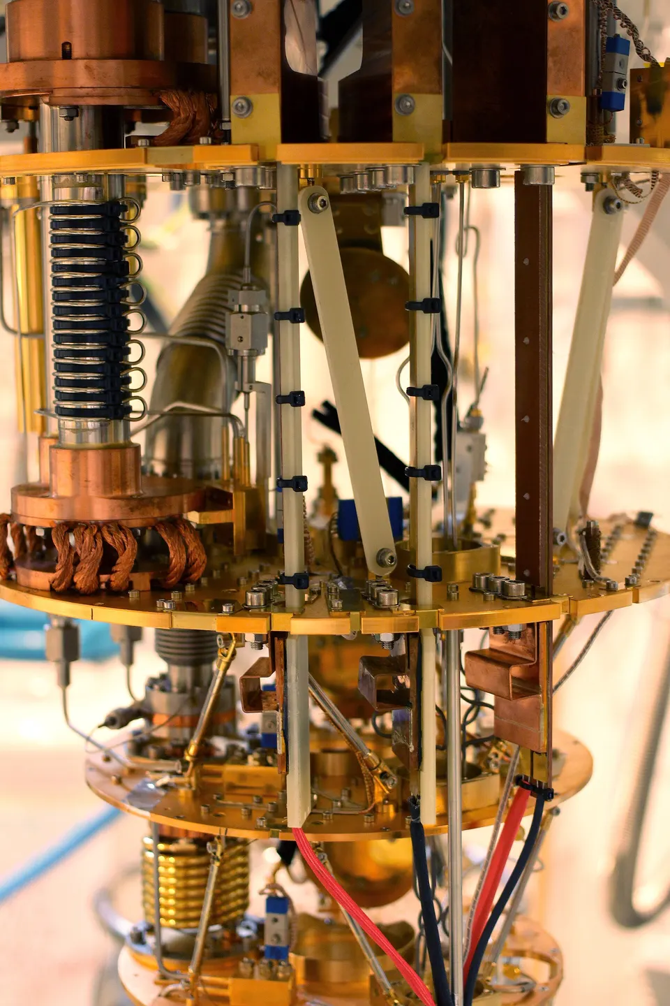 An open dilution refrigerator at UCL, not D-Wave's: each shelf is colder down to 0.03 K, the cooling D-Wave's gate-model qubits share with its annealers