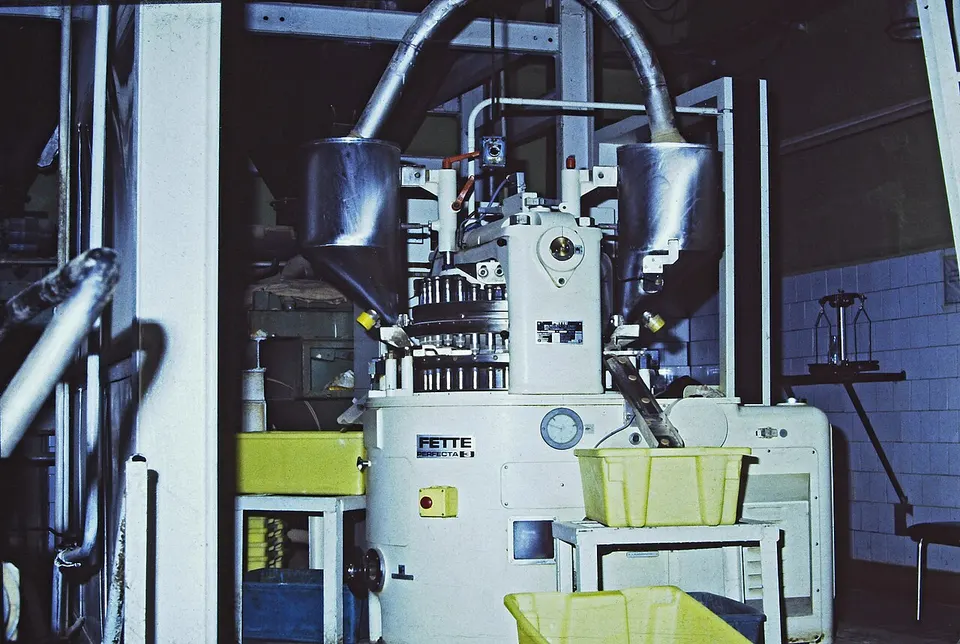 An industrial tablet press: small-molecule pills like orforglipron are made on standard lines like this, not in peptide plants