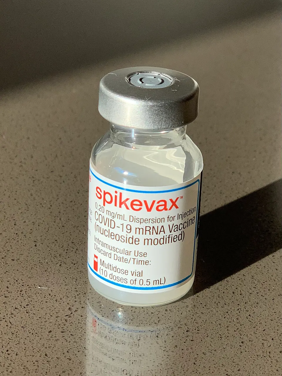 An mRNA vaccine vial: the same kind of lipid-nanoparticle 'fat bubble' packaging VERVE-102 uses to carry its editor to the liver
