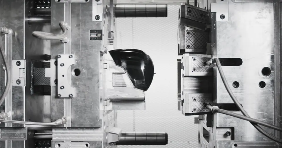 A steel injection mould at BotQ opening on a moulded robot part: seconds per part instead of a week on a CNC machine