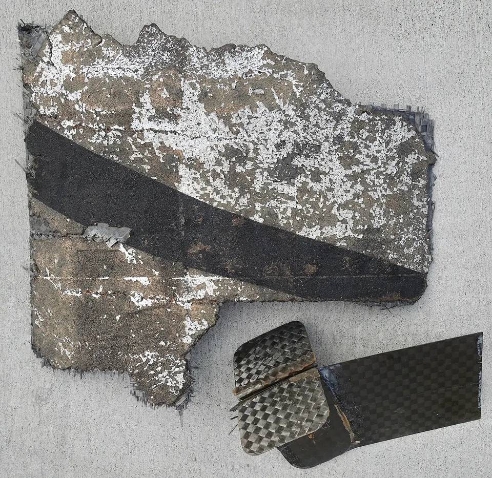 Pieces recovered from Alpha's first flight: the outer skin and an inner rib, both woven carbon-fibre composite rather than metal