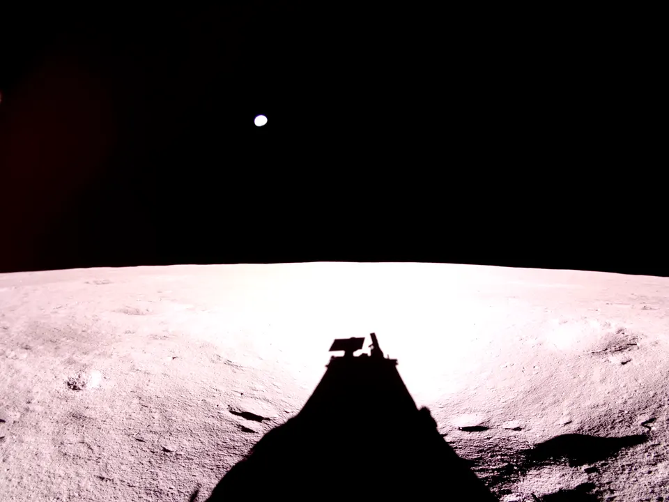 Blue Ghost's own camera after landing: the lander's shadow, solar panel on top, stretches across the Moon with Earth overhead