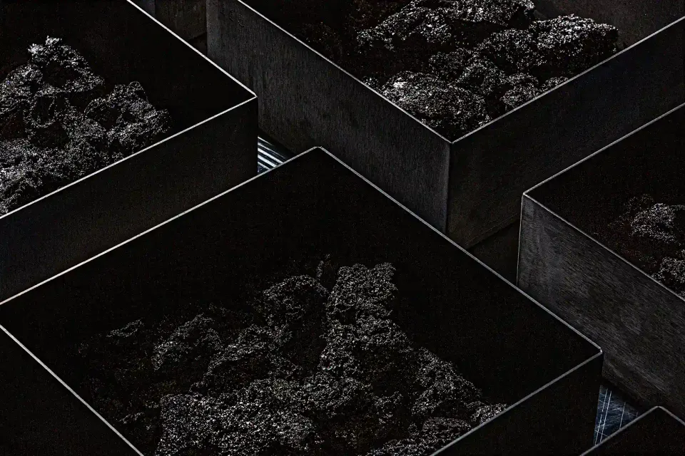 Group14's silicon-carbon anode material in trays: porous carbon with silicon grown inside the pores, shipped as a black powder