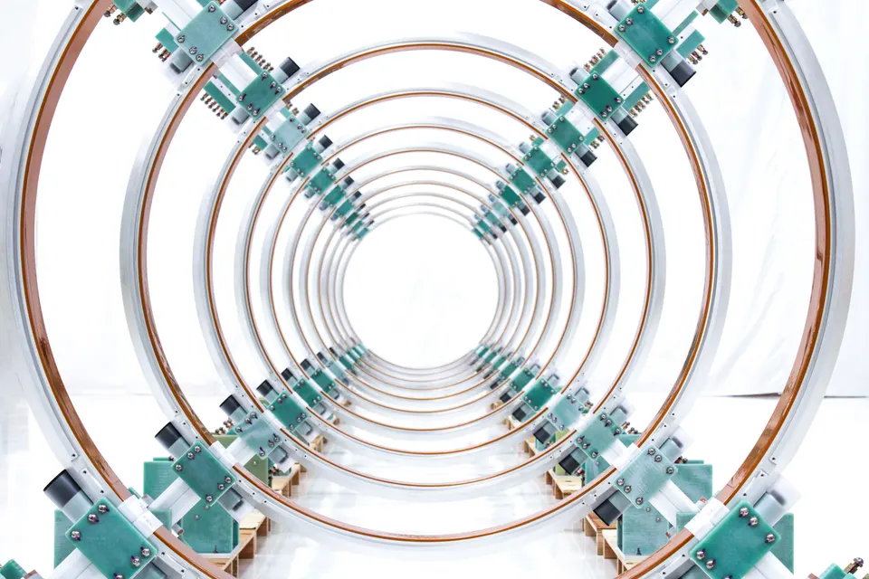 Looking down the ring magnets of an earlier Helion machine; Orion lines up the same kind of coils at larger scale