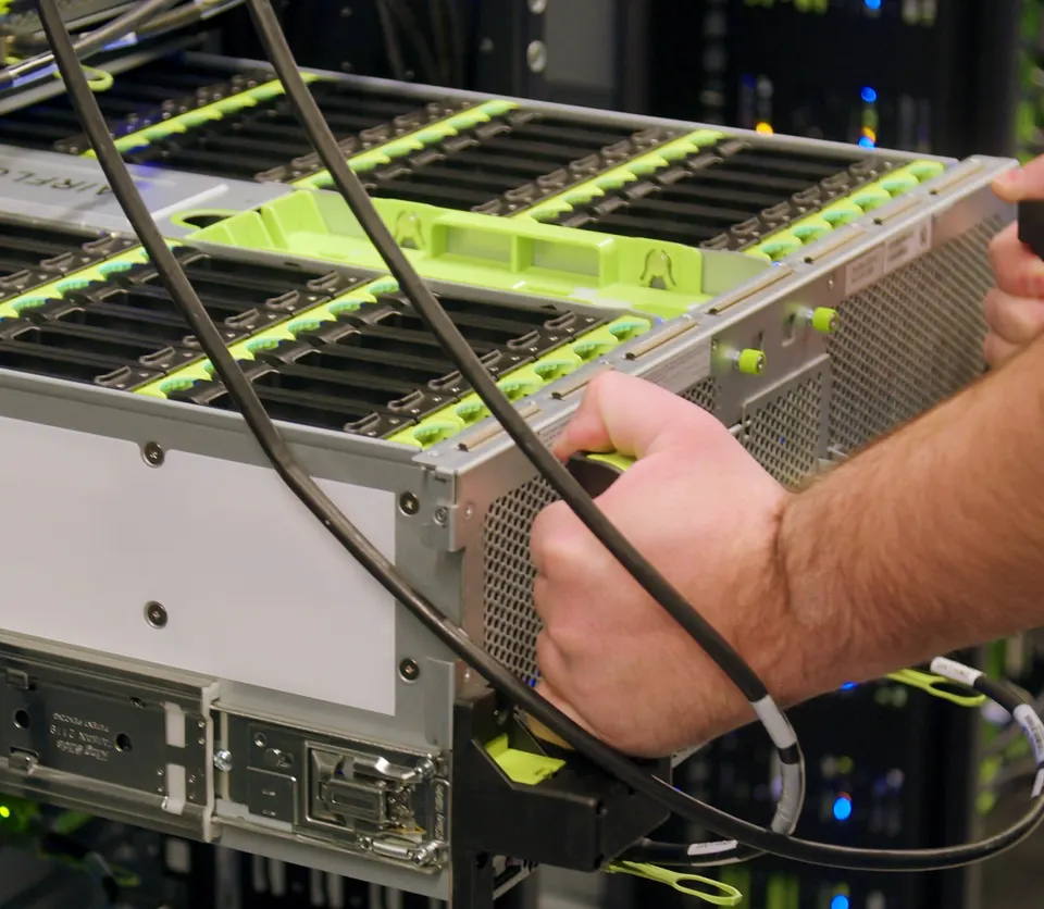 A technician cabling a server in a Meta data centre: Llama is trained and served on Meta's own fleet of machines like this