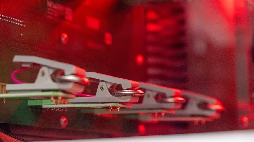 Coin-size test cells clipped into a lab rig: how new cathode recipes, like Mitra's iron-phosphate blends, are charged and checked