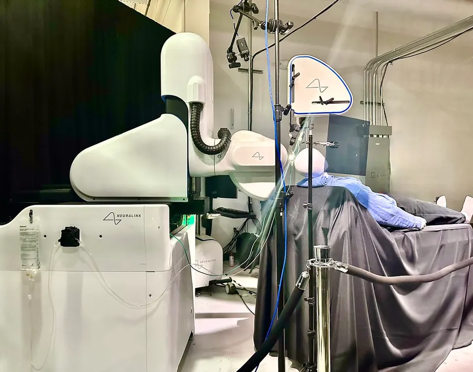 Neuralink's surgical robot demonstrating electrode insertion on a model head (2022); Blindsight uses the same robot and implant, placed over the vision area