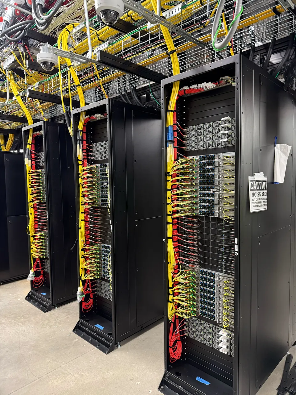 Server racks and network cabling inside a Stargate data hall (OpenAI photo)