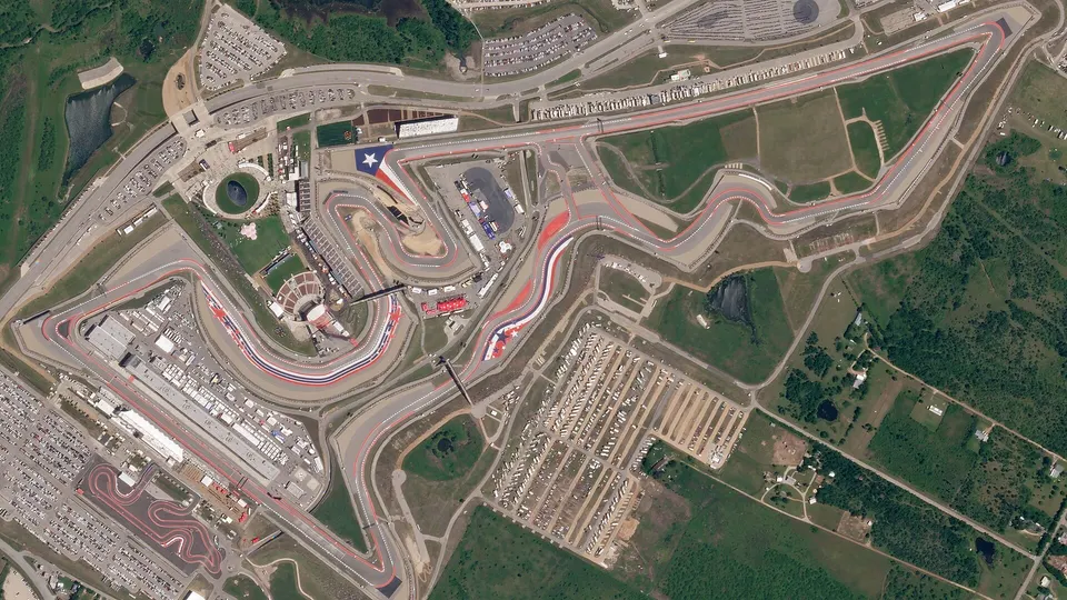 Not Pelican: a Texas race track seen by Planet's older SkySat, cars in the lots just visible; Pelican's sharper telescope resolves finer detail