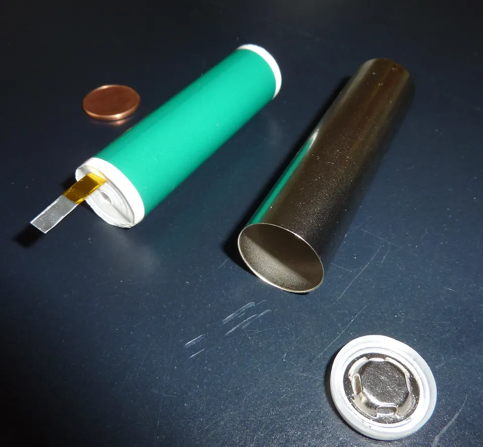 A small cylindrical lithium-ion cell taken apart: rolled electrode sheets and the steel can. R2's LG 4695 cells share the design, far larger