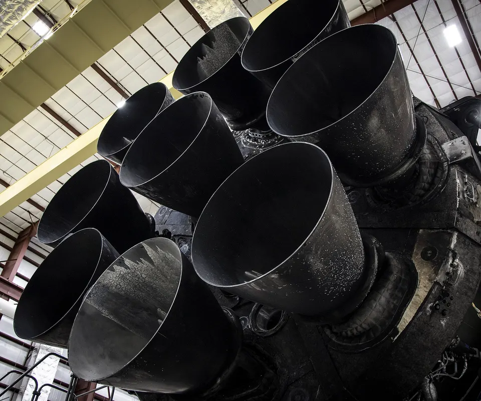 The nine Merlin engines under a flown Falcon 9 first stage, back in the hangar after landing for reuse
