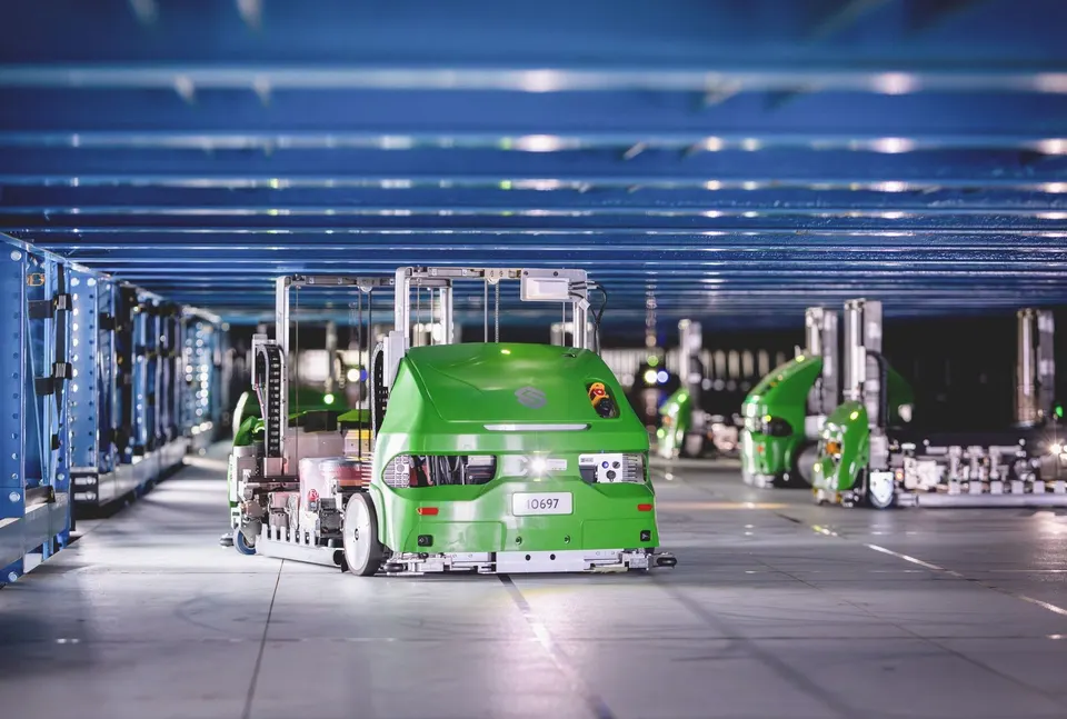 Symbotic's wheeled bots racing along a level of the storage structure, fetching cases from the racks at the sides