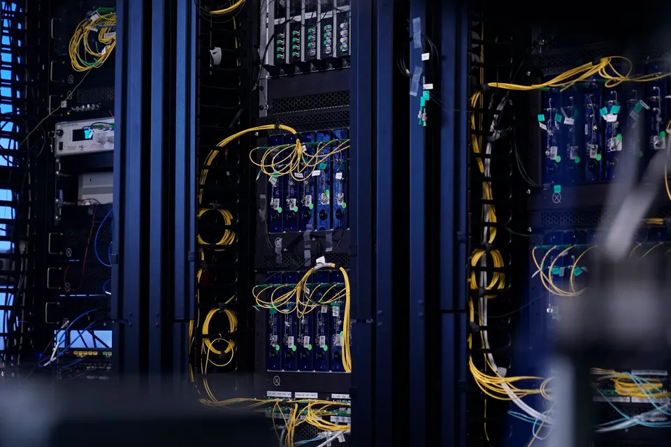 Xanadu's photonic computing racks, shot when Aurora was unveiled: chips sit in separate racks, linked by the yellow optical fibres