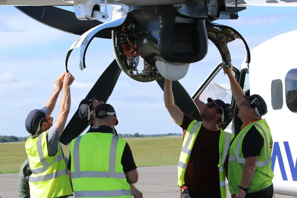 Engineers at the open nacelle of ZeroAvia's Dornier 228 testbed: the electric motor that fuel-cell power drives, turning the propeller